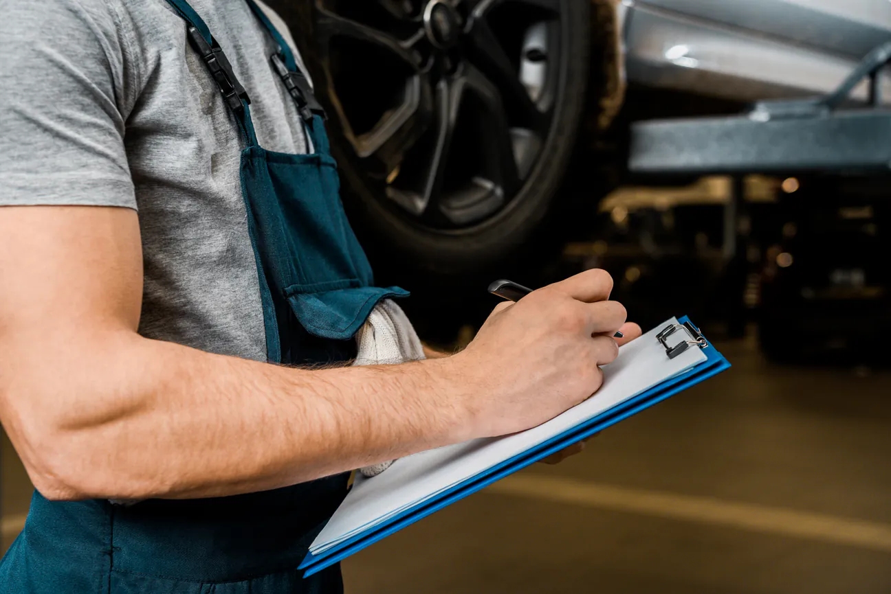 Virginia State Inspection Check mechanic with a checklist inspecting a car in the shop