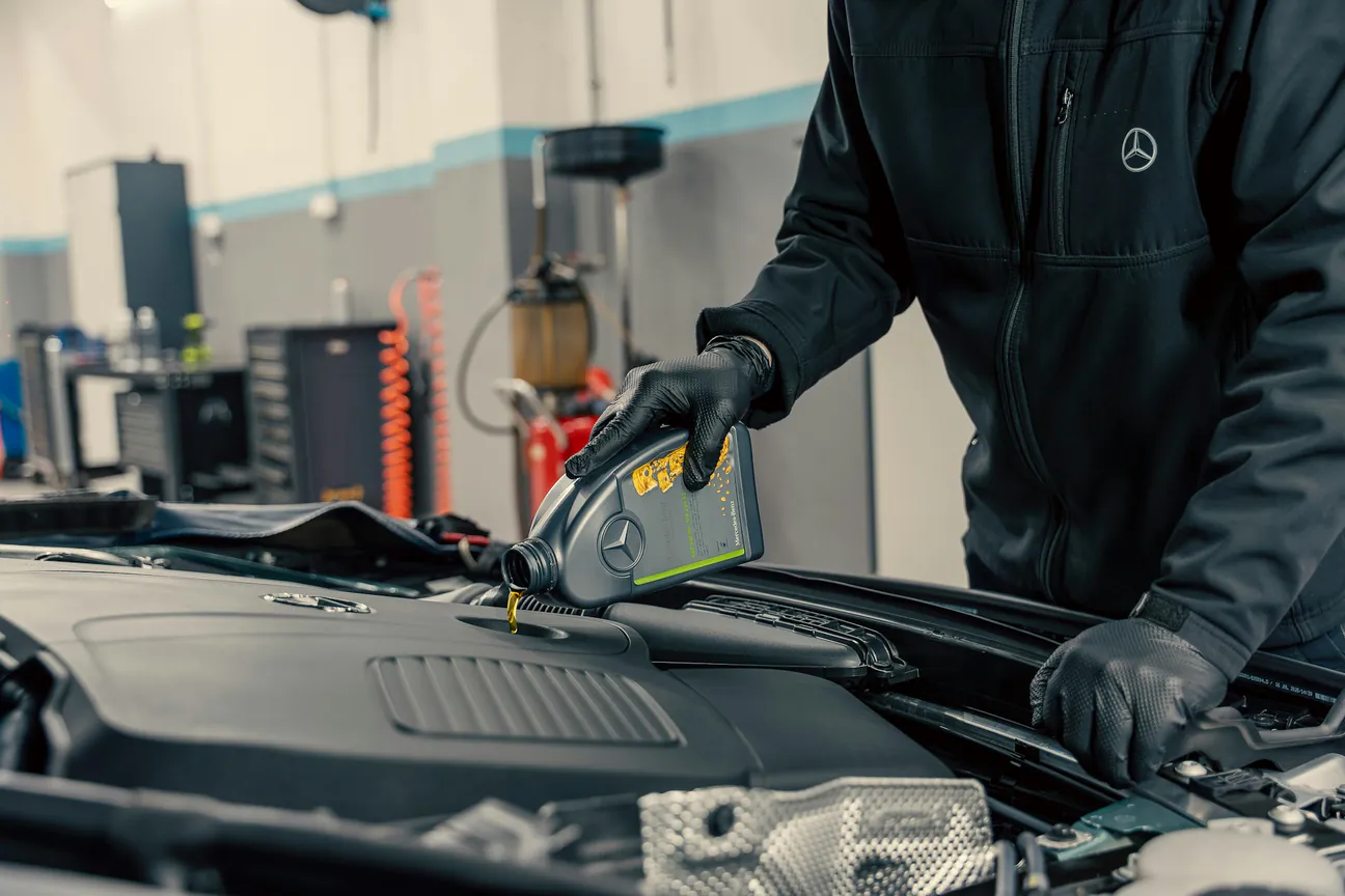 Oil Change Service mechanic pouring fresh oil during a back-to-school service